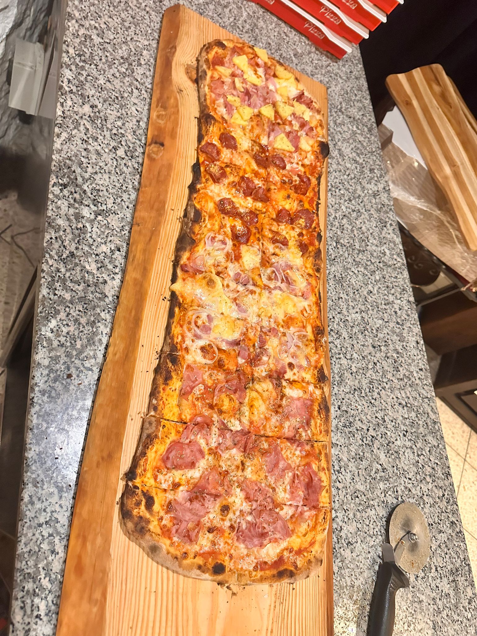 Tagliere extra lungo con una pizza al metro appena servita